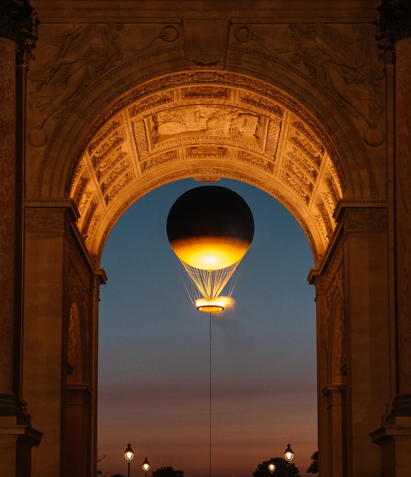 La vasque de la flamme olympique s'élevant au-dessus des Tuileries au crépuscule