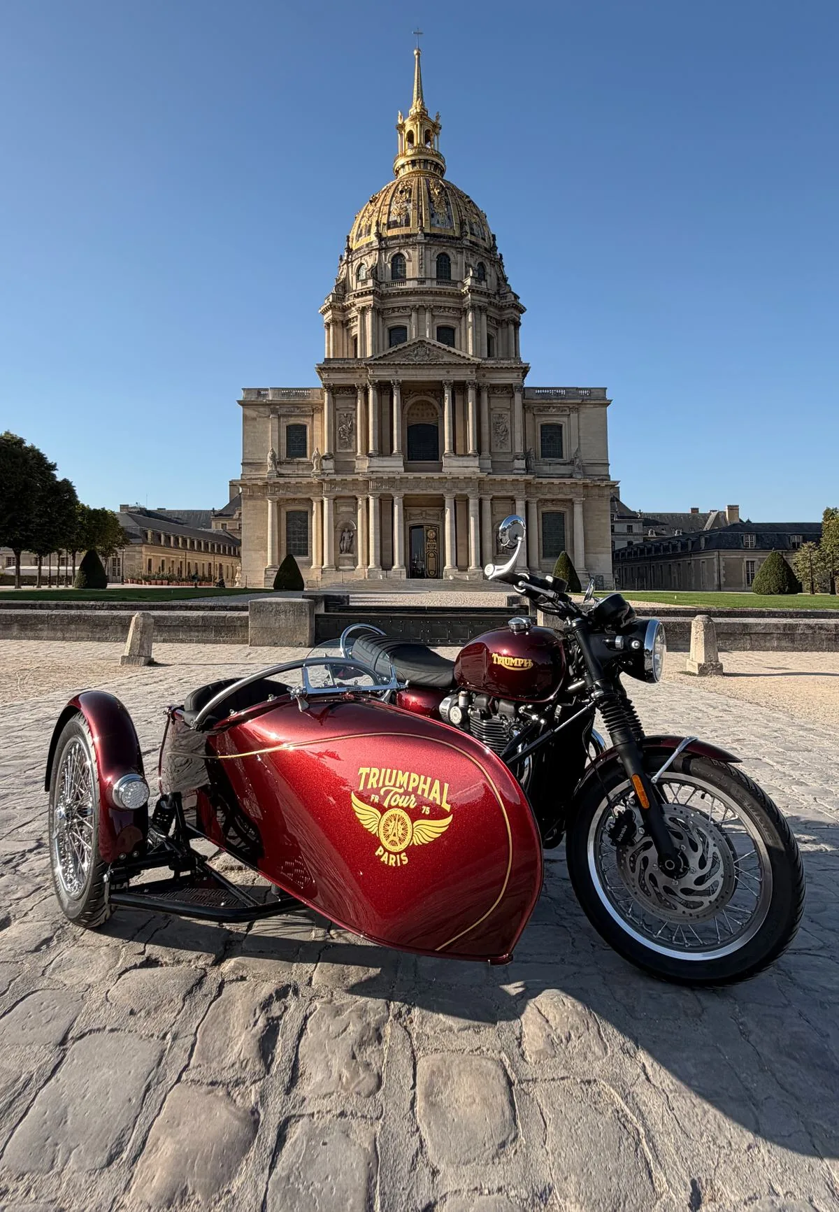 Side-car Triumph rouge de l'Iconic Tour devant les Invalides
